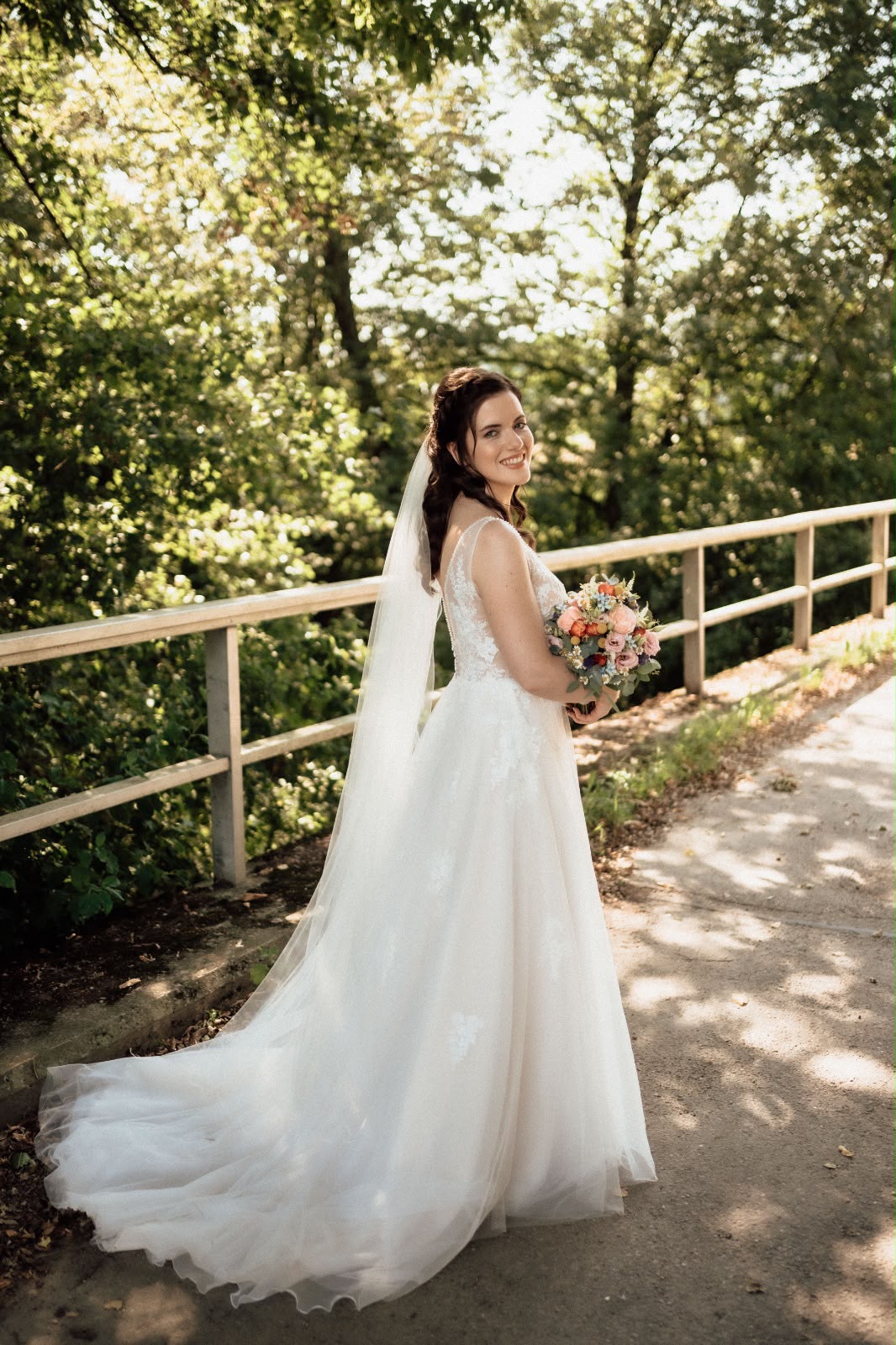 Braut im Brautkleid mit Schleier und Brautstrauß